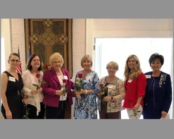 Group standing some holding roses.